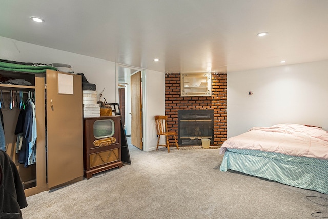 bedroom with a fireplace, light carpet, and a closet