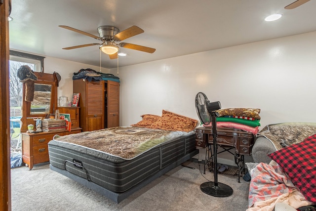 carpeted bedroom featuring multiple windows and ceiling fan