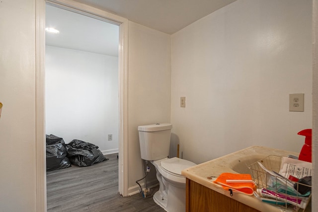 bathroom with hardwood / wood-style floors, vanity, and toilet