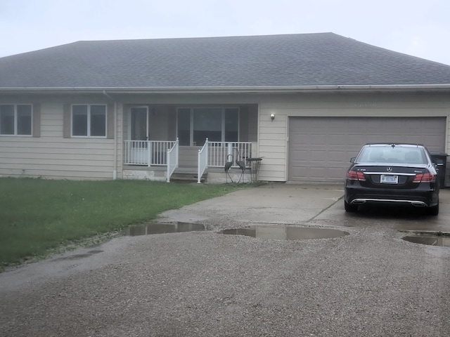 ranch-style house featuring covered porch and a garage