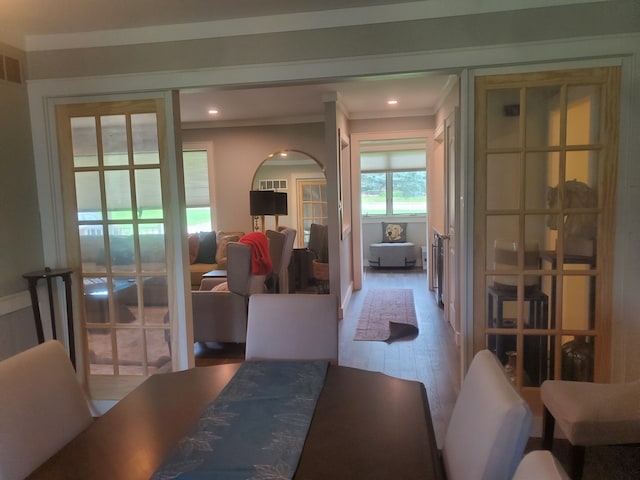 dining area with ornamental molding and hardwood / wood-style flooring