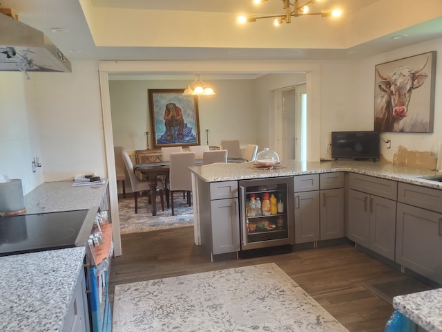 kitchen featuring light stone countertops, ventilation hood, electric stove, dark hardwood / wood-style floors, and wine cooler