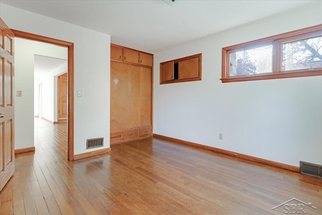 unfurnished bedroom featuring a closet and light wood-type flooring