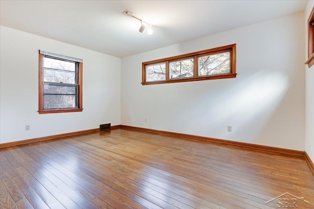 spare room with light hardwood / wood-style flooring and a healthy amount of sunlight