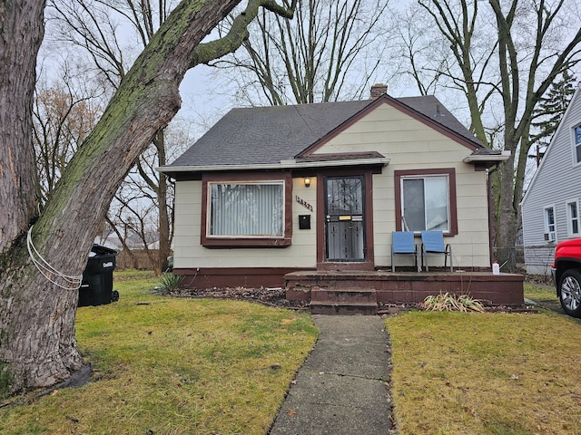 19356 Huntington Rd, Detroit, MI 48219 - bungalow-style home with a chimney, roof with shingles, a front lawn, and covered porch