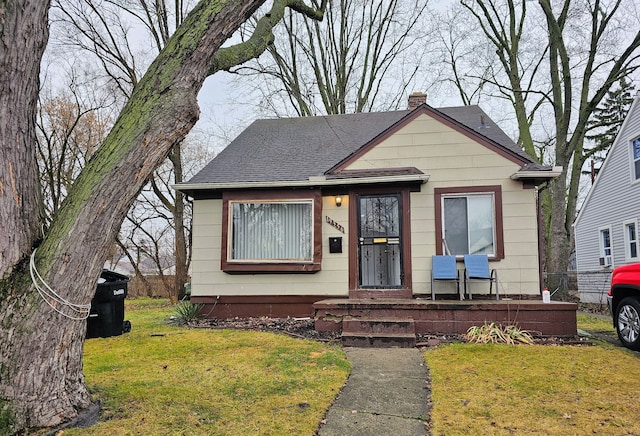 19356 Huntington Rd, Detroit, MI 48219 - view of front of house featuring a front lawn, a chimney, and roof with shingles