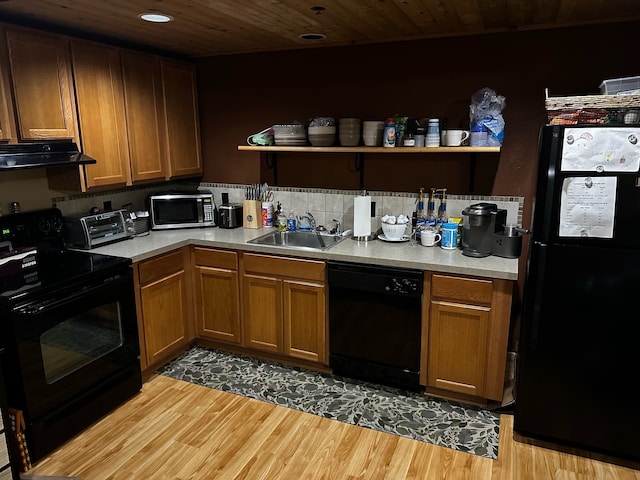 kitchen with extractor fan, sink, light hardwood / wood-style flooring, and black appliances