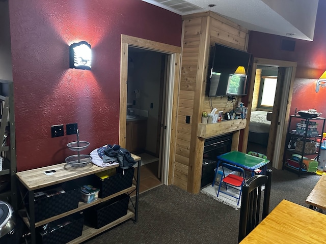 interior space with dark carpet and wooden walls