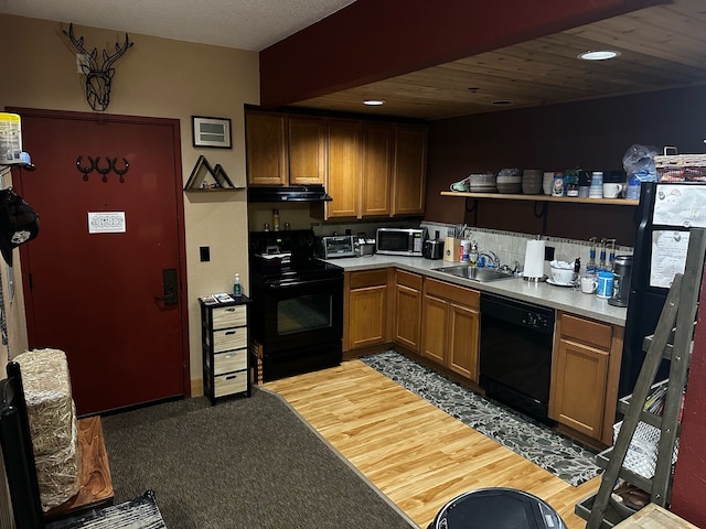 kitchen featuring sink, black appliances, and light wood-type flooring