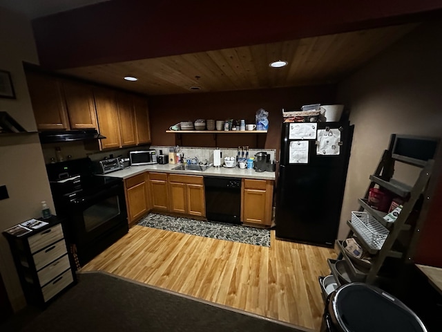 kitchen with black appliances, light wood-type flooring, and sink