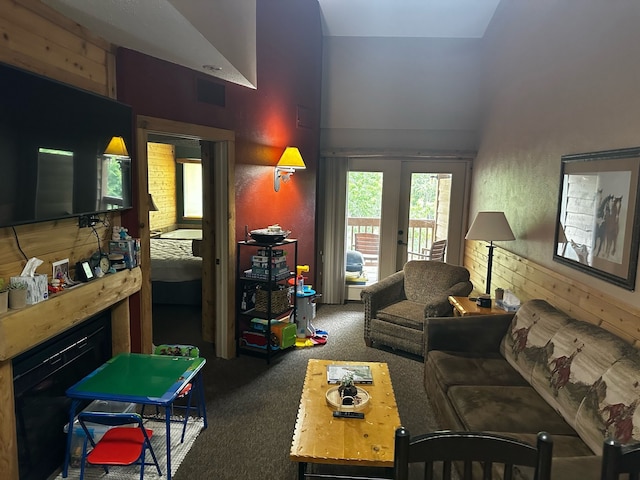 carpeted living room featuring french doors and wood walls