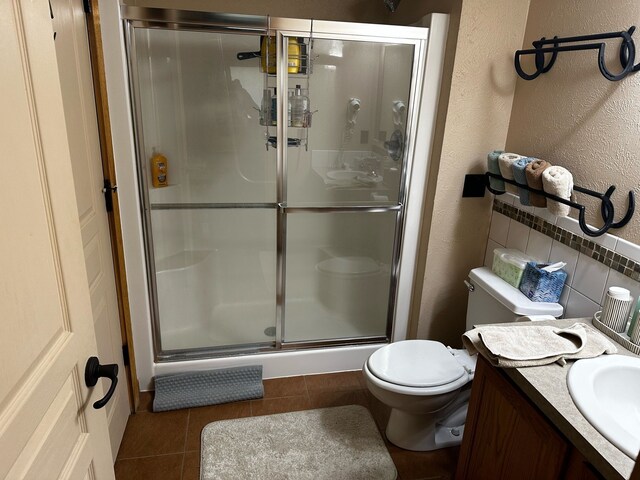 5900 Water Rd Unit 313, Rothbury, MI 49452 - bathroom with a stall shower, tile patterned flooring, toilet, a textured wall, and vanity