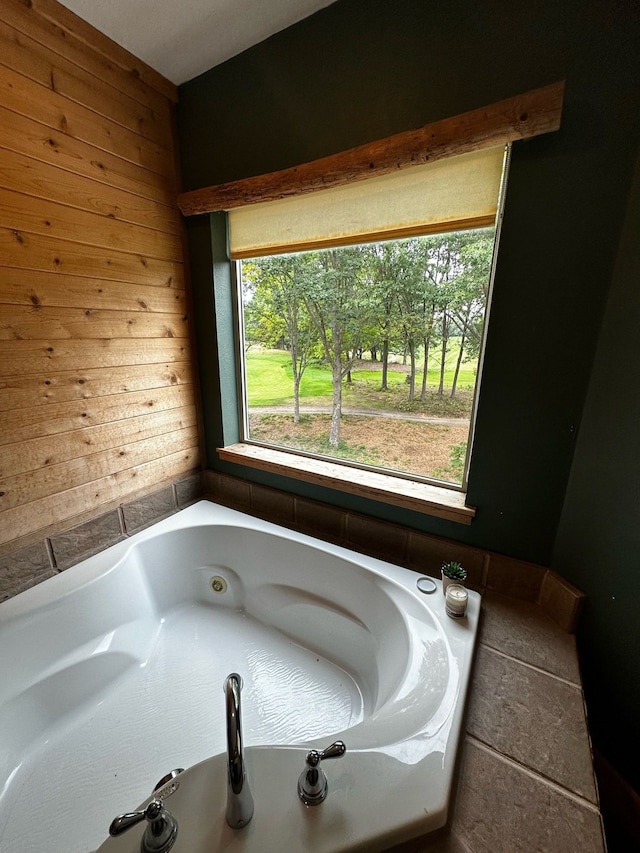 bathroom featuring a bathing tub and wood walls