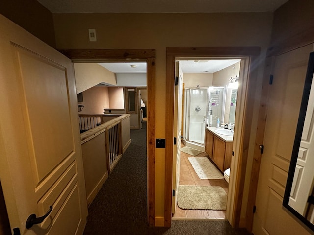 hall featuring sink and light carpet