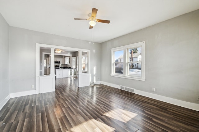 unfurnished living room featuring ceiling fan and dark hardwood / wood-style flooring