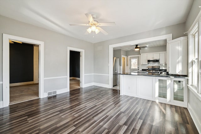 kitchen featuring white cabinets, dark hardwood / wood-style floors, stainless steel appliances, and a wealth of natural light