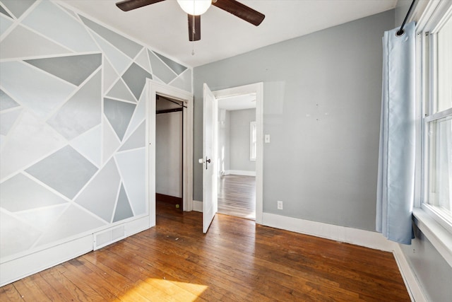 unfurnished bedroom with a closet, hardwood / wood-style flooring, and ceiling fan