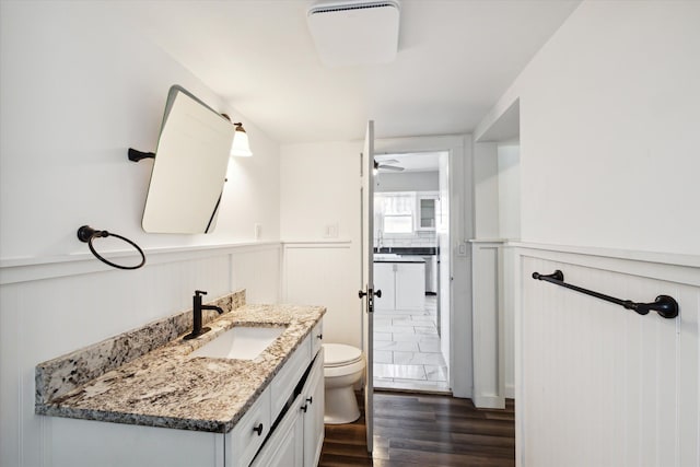 bathroom featuring hardwood / wood-style floors, ceiling fan, toilet, and vanity