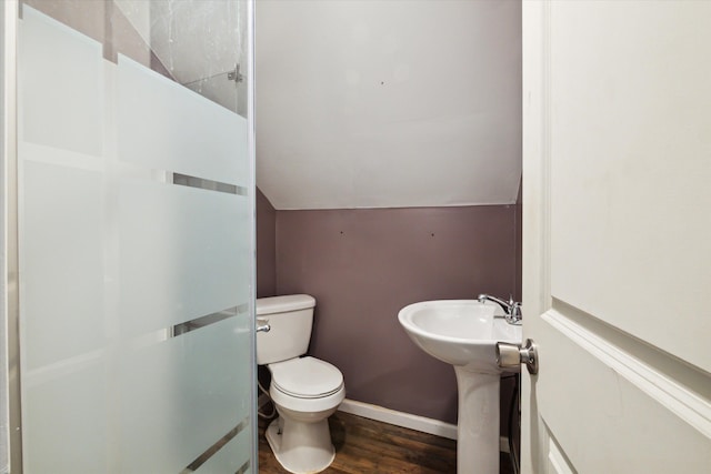 bathroom featuring wood-type flooring, lofted ceiling, and toilet