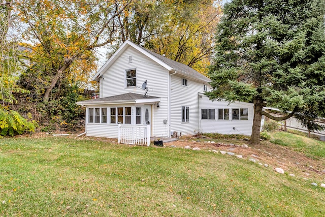 back of property with a sunroom and a yard