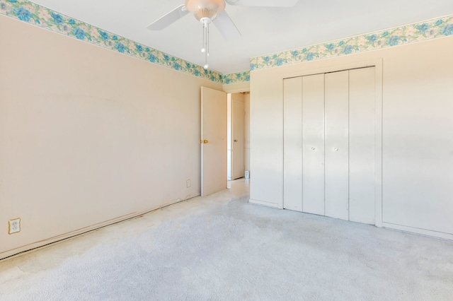 unfurnished bedroom with a closet, ceiling fan, and light colored carpet