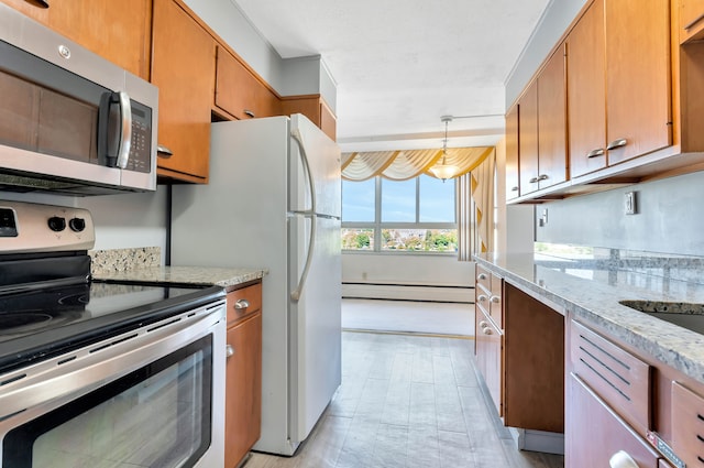 kitchen featuring light stone countertops, pendant lighting, a baseboard radiator, and appliances with stainless steel finishes