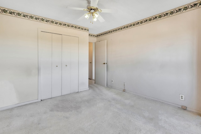 unfurnished bedroom featuring ceiling fan, a closet, and light carpet