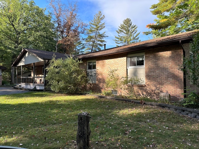 view of side of home with a yard