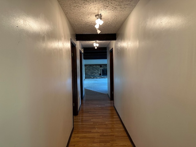 corridor featuring wood-type flooring and a textured ceiling