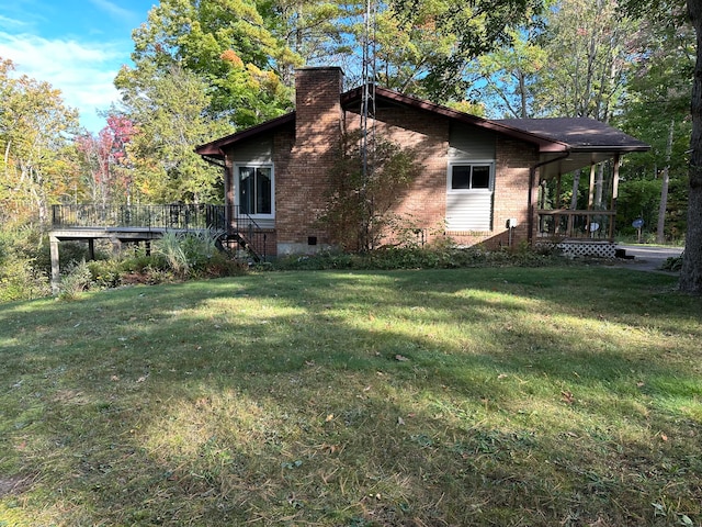 view of side of property featuring a lawn and a wooden deck