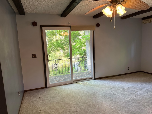 carpeted empty room with beamed ceiling, ceiling fan, and a textured ceiling