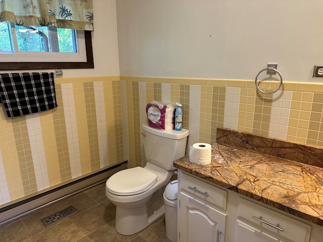 bathroom featuring tile patterned floors, tile walls, and toilet