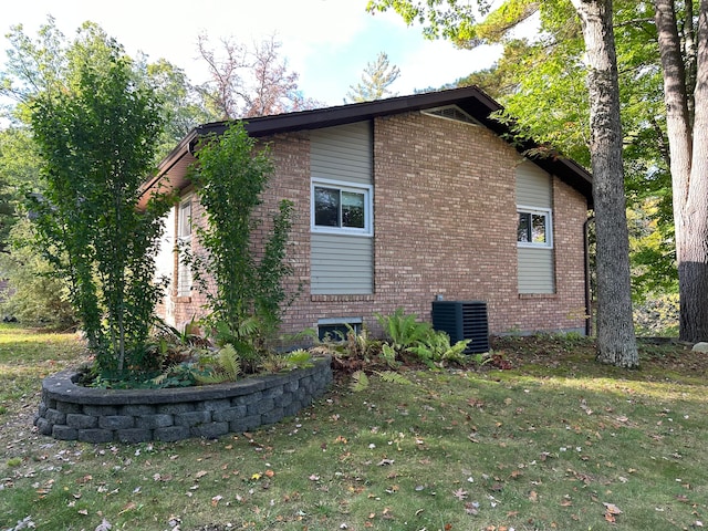 view of property exterior with central air condition unit and a yard