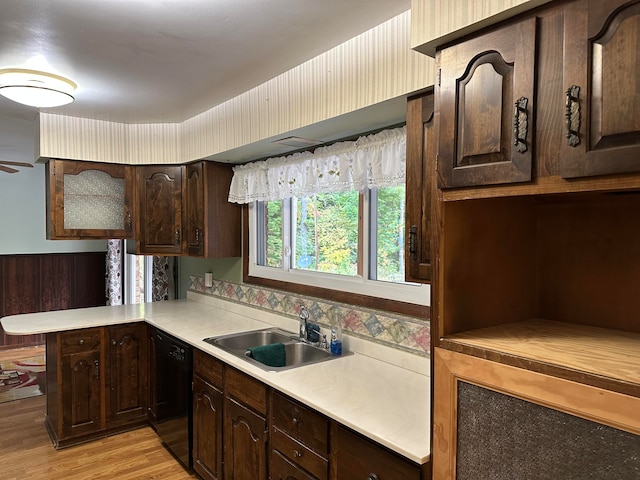 kitchen with dishwasher, dark brown cabinets, sink, and light hardwood / wood-style flooring