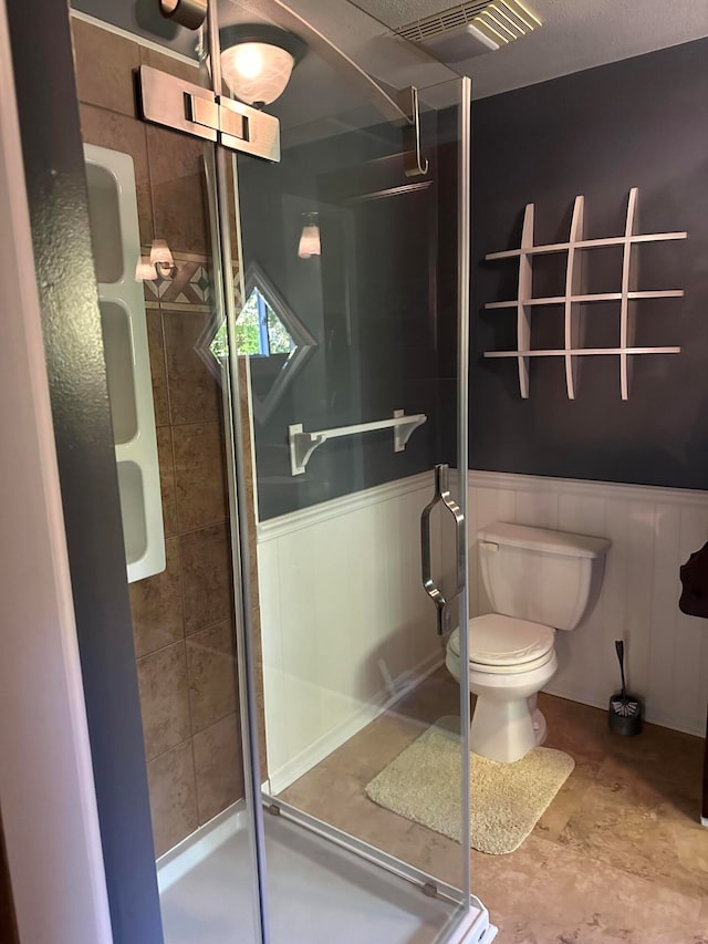 bathroom with toilet and a shower with shower door