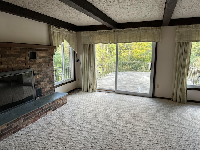 unfurnished living room with beam ceiling, carpet, and a brick fireplace