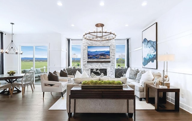 living room featuring a fireplace, dark hardwood / wood-style floors, and a notable chandelier