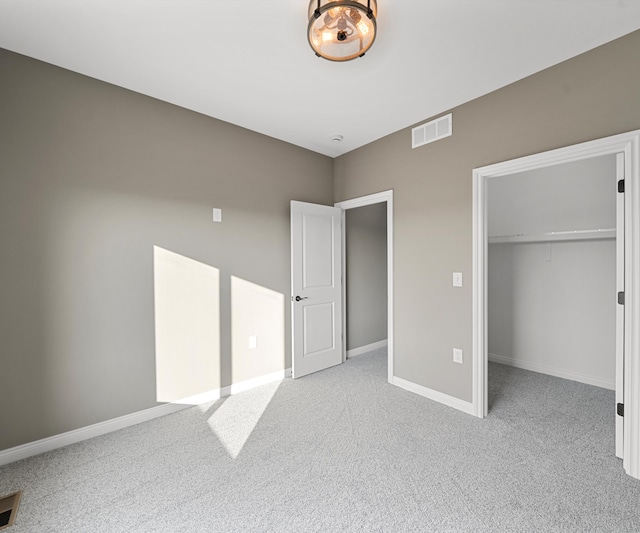 unfurnished bedroom with carpet floors, a closet, visible vents, and baseboards