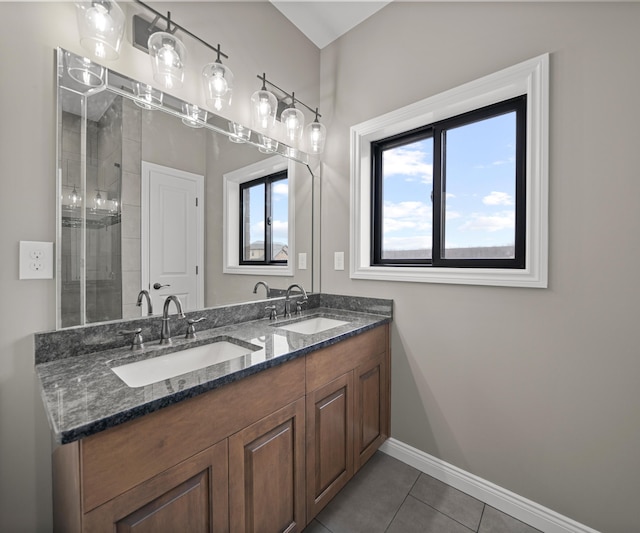 bathroom featuring baseboards, a sink, and a healthy amount of sunlight