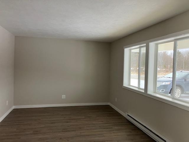 2715 Sawyer Rd, Traverse City, MI 49685 - spare room featuring a baseboard radiator, dark wood-style floors, and baseboards