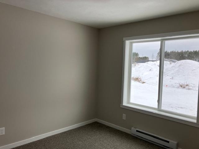 2715 Sawyer Rd, Traverse City, MI 49685 - empty room with a baseboard heating unit, plenty of natural light, dark colored carpet, and baseboards