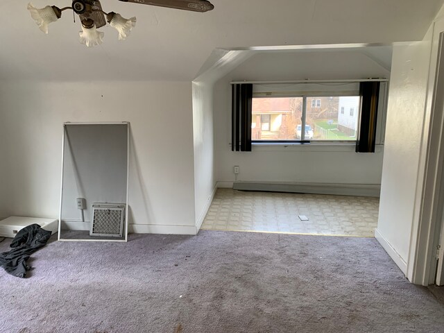 carpeted empty room with vaulted ceiling