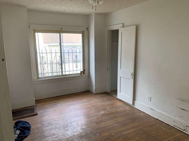 unfurnished bedroom with hardwood / wood-style floors and a textured ceiling