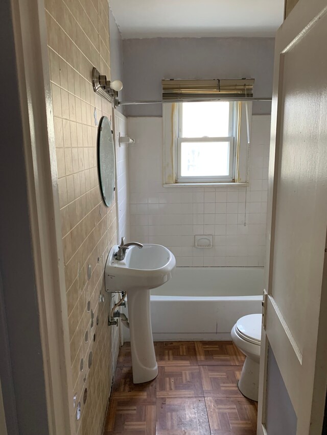 full bathroom with parquet floors, sink, shower / bathing tub combination, tile walls, and toilet