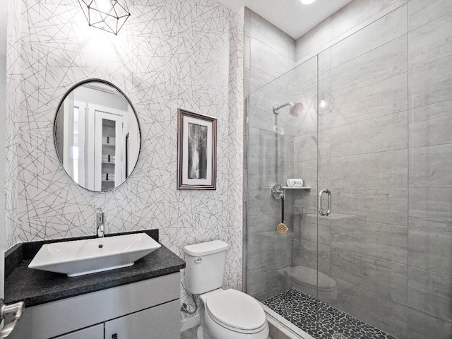 bathroom featuring walk in shower, vanity, tile walls, and toilet