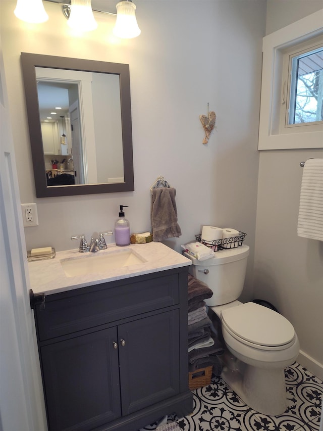 122 Park Ave, Frankfort, MI 49635 - half bath with vanity, toilet, tile patterned flooring, and baseboards