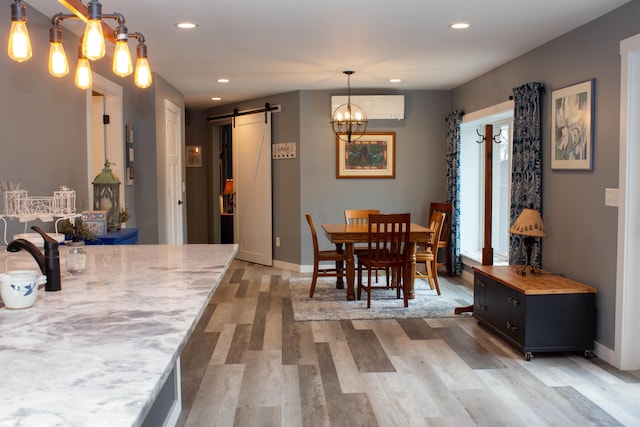 122 Park Ave, Frankfort, MI 49635 - dining space featuring a barn door, recessed lighting, light wood finished floors, baseboards, and a chandelier