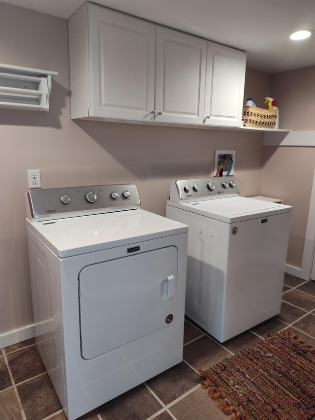 122 Park Ave, Frankfort, MI 49635 - laundry area featuring separate washer and dryer, cabinet space, dark tile patterned floors, and baseboards