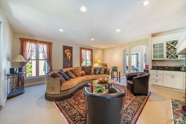 living room featuring light colored carpet and indoor bar