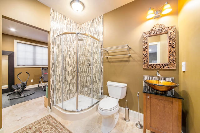 bathroom featuring vanity, toilet, and a shower with door